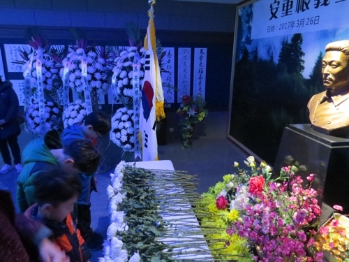 South Korean children offer a silent prayer in front of independence fighter Ahn Jung-geun's torso at the memorial hall for him during a ceremony in the city of Dailian, northeastern China, to mark the 107th anniversary of the execution by the Japanese of Ahn, who assassinated a top Japanese official more than a century ago. (Yonhap)