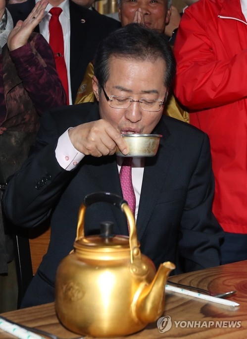 Hong Joon-pyo, presidential nominee of the Liberty Korea Party, drinks traditional rice wine known as "makgeolli" at a market in Andong, 268 kilometers southeast of Seoul, on April 14, 2017. (Yonhap)