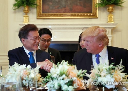 South Korean President Moon Jae-in (L) shakes hands with U.S. President Donald Trump at a dinner hosted by the U.S. leader and his wife, Melania, at the White House on June 29, 2017. (Yonhap)