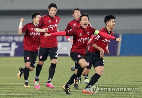 Sangju Sangmu players celebrate after they beat Busan IPark FC on penalties in the K League promotion-relegation playoff at Sangju Civic Stadium in Sangju, North Gyeongsang Province, on Nov. 26, 2017. (Yonhap)