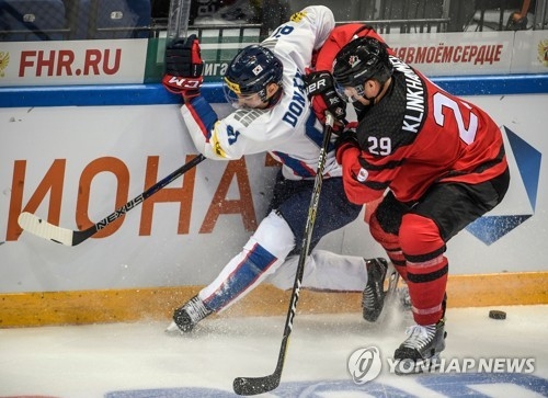 In this AFP photo, Canadian forward Rob Klinkhammer (R) battles South Korean defenseman Lee Don-ku during the teams' Channel One Cup game at VTB Ice Palace in Moscow on Dec. 13, 2017. (Yonhap)