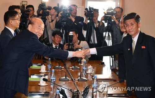 This photo taken by joint press corps shows Park Kyung-seo (L), South Korea's chief delegate, shaking hands with his North Korean counterpart Pak Yong-il (R) before the start of inter-Korean Red Cross talks at a hotel on Mount Kumgang on the North's east coast on June 22, 2018. (Yonhap)