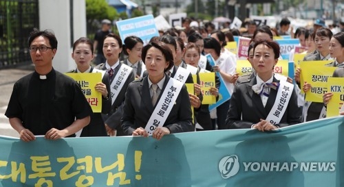 A group of sacked KTX crew members, dressed in uniform, marches toward the presidential office Cheong Wa Dae in Seoul on June 18, 2018, to deliver a letter calling for a meeting with President Moon Jae-in. (Yonhap) 