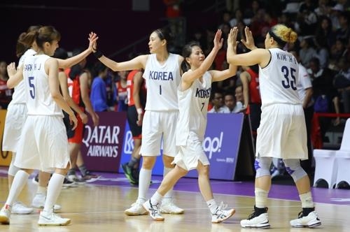 Members of the unified Korean women's basketball team high-five each other after taking a 58-20 first-half lead over Indonesia in the teams' preliminary action at the 18th Asian Games at GBK Basketball Hall in Jakarta on Aug. 15, 2018. (Yonhap)