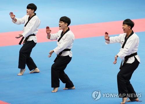 South Korean taekwondo practitioners Kim Seon-ho (L), Han Yeong-hun (C) and Kang Wang-jin compete in the men's team poomsae final at the 18th Asian Games in Jakarta on Aug. 19, 2018. (Yonhap)
