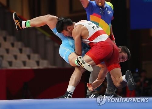 South Korean Greco-Roman wrestler Ryu Han-su (R) takes down Almat Kebispayev of Kazakhstan during the men's 67kg division final at the 18th Asian Games at Jakarta Convention Center Assembly Hall in Jakarta on Aug. 21, 2018. (Yonhap)