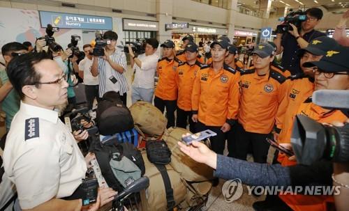 Jeong Moon-ho (L), commissioner of the National Fire Agency, welcomes South Korean rescuers, who participated in a search and rescue operation for missing South Korean tourists in Hungary, at Incheon International Airport, west of Seoul, on July 30, 2019. (Yonhap)