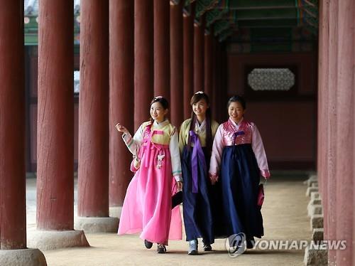 This undated file photo shows foreign tourists wearing traditional Korean clothes visiting a royal palace in Seoul. (Yonhap)