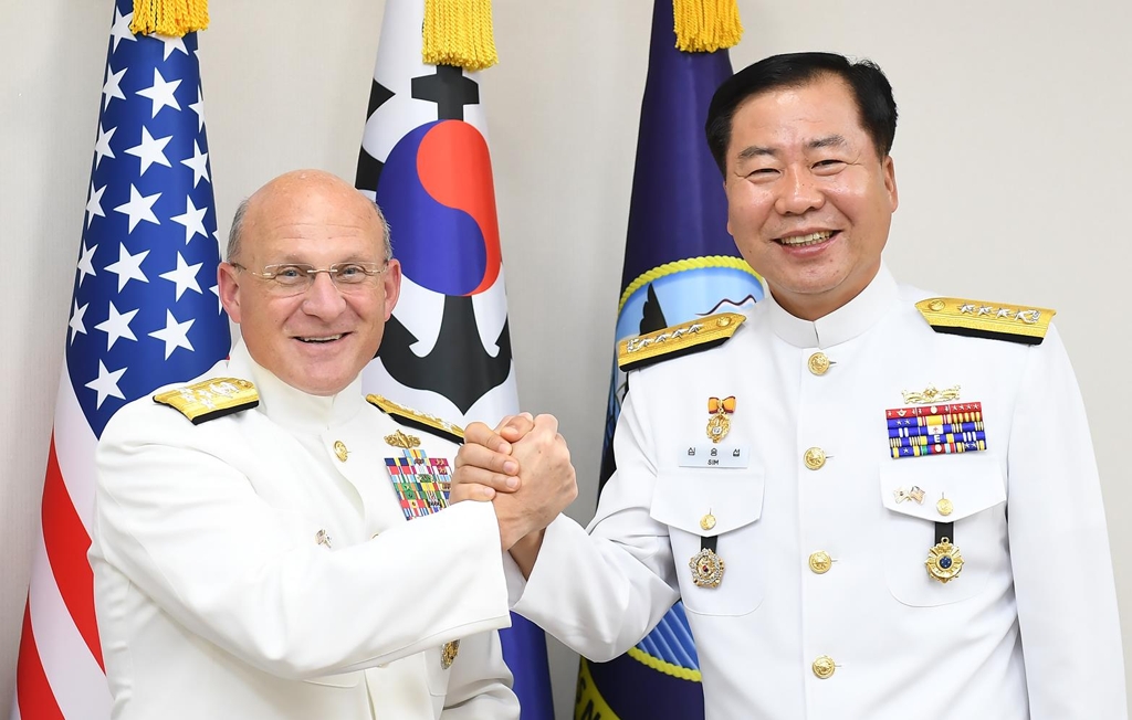 South Korea's Chief of Naval Operations Adm. Sim Seung-seob (R) and U.S. Chief of Naval Operations Adm. Michael Gilday clasp hands ahead of their talks in Seoul on Sept. 25, 2019, in this photo provided by the Navy. (PHOTO NOT FOR SALE) (Yonhap)