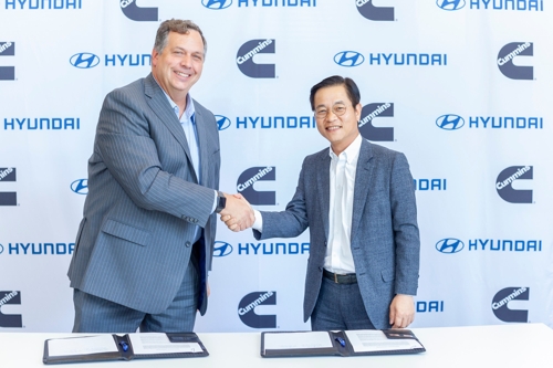 In this undated photo provided by Hyundai Motor, Hyundai Motor Vice President Kim Sae-hoon (R), head of the carmaker's fuel cell business, and Cummins Vice President Thad Ewald shake hands after signing a memorandum of understanding for collaboration on hydrogen fuel-cell technology. (PHOTO NOT FOR SALE) (Yonhap)
