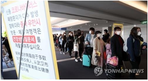 People wearing masks wait in line to go through quanantine at Incheon International Airport on Jan. 28, 2020. (Yonhap)
