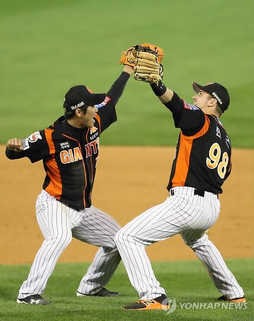 In this file photo from Oct. 13, 2017, Andy Burns (R) and Shin Bon-ki of the Lotte Giants celebrate their 7-1 victory over the NC Dinos in Game 4 of the Korea Baseball Organization first round playoff series at Masan Stadium in Changwon, 400 kilometers southeast of Seoul. (Yonhap)