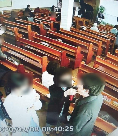 This photo provided by the government of Gyeonggi Province shows an official of the River of Grace Community Church spraying salt water into the mouth of a church member. (PHOTO NOT FOR SALE) (Yonhap)