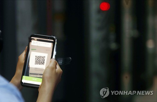 A local government official from Gwangju, 330 kilometers south of Seoul, checks if QR code logs are working at a karaoke establishment on June 9, 2020, in this photo provided by the government office of Buk Ward. (PHOTO NOT FOR SALE) (Yonhap)