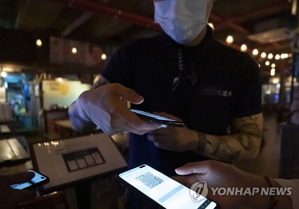 A customer gets a QR code via a smartphone app at a bar in Seoul on June 10, 2020, the first day of the mandatory QR code-based registration of visitors at bars, clubs and other entertainment facilities across the country to stem the spread of the new coronavirus. (Yonhap) (END)