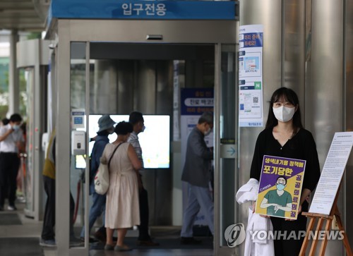 A medical student holds a sign supporting the strike by trainee doctors at Seoul National University Hospital on Aug. 21, 2020. (Yonhap) 