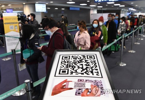 In this photo taken on Feb. 13, 2020, outbound passengers wait in a long queue to leave for Hong Kong at Incheon International Airport in Incheon, just west of Seoul. (Yonhap)