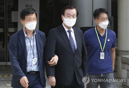 Police escort Kim Kyung-jae (C), a former head of the Korea Freedom Federation, at the Seoul Central District Court on Sept. 28, 2020, after a hearing to review the prosecution's request of a warrant for Kim's arrest. (Yonhap)