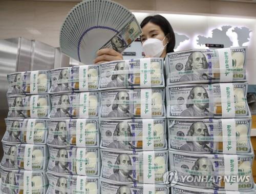 This file photo shows a Hana Bank official in Seoul inspecting U.S. banknotes before their release into the local financial market. (Yonhap)