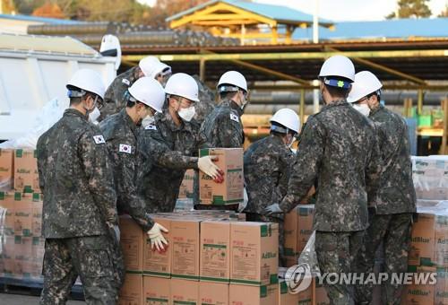 Soldiers move boxes of urea at the Army's First Logistic Support Brigade in Goyang, north of Seoul, on Nov. 11, 2021, to provide them to the civic sector suffering a severe supply shortage due to China's sudden export curbs, in this photo provided by the Korea Defense Daily. (PHOTO NOT FOR SALE) (Yonhap)