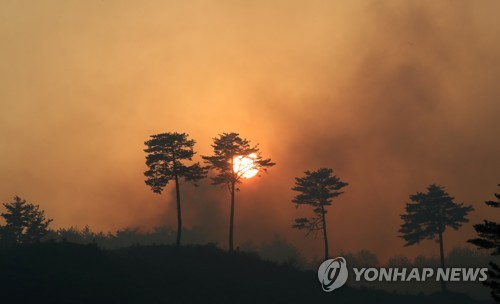 A wildfire burns in a village of the northeastern county of Yangyang on April 22, 2022. (Yonhap)