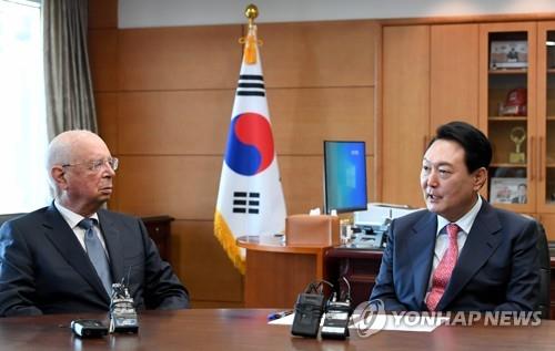 South Korea's President-elect Yoon Suk-yeol (R) talks with World Economic Forum Chairman Klaus Schwab during a meeting in his Seoul office on April 27, 2022. (Pool photo) (Yonhap)