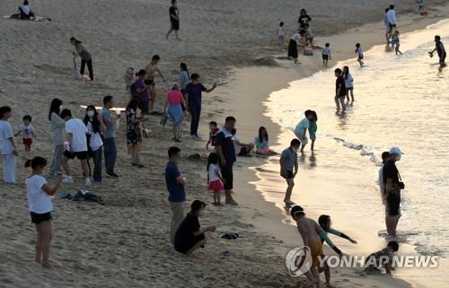 People are out late at the beach in Gangneung Province on June, 26, 2022, to seek refuge from the hot weather that did not cool down even after sunset. (Yonhap)