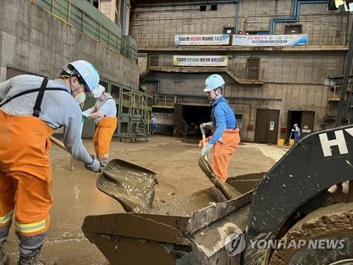 Workers remove mud at POSCO in the southeastern city of Pohang on Sept. 7, 2022, in this photo provided by the steelmaker. (PHOTO NOT FOR SALE) (Yonhap)