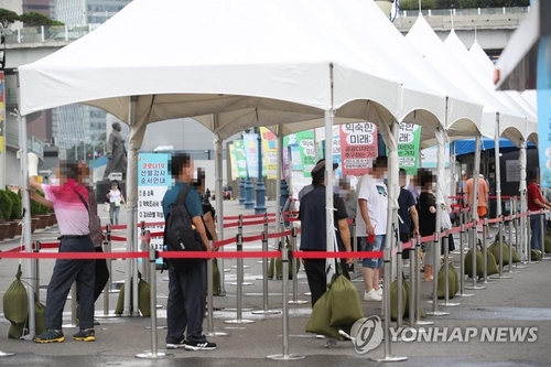 Des gens font la queue dans un centre de dépistage provisoire installé devant la gare de Séoul pour se soumettre à un test de dépistage du nouveau coronavirus (Covid-19), le samedi 31 juillet 2021.