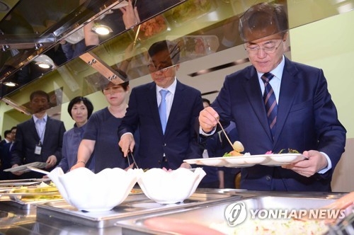 職員食堂でプレートに料理を盛る文大統領（右端）＝１２日、ソウル（聯合ニュース）