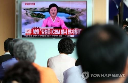 ソウル駅で北朝鮮の発表を報じるニュースを見つめる市民＝４日、ソウル（聯合ニュース）