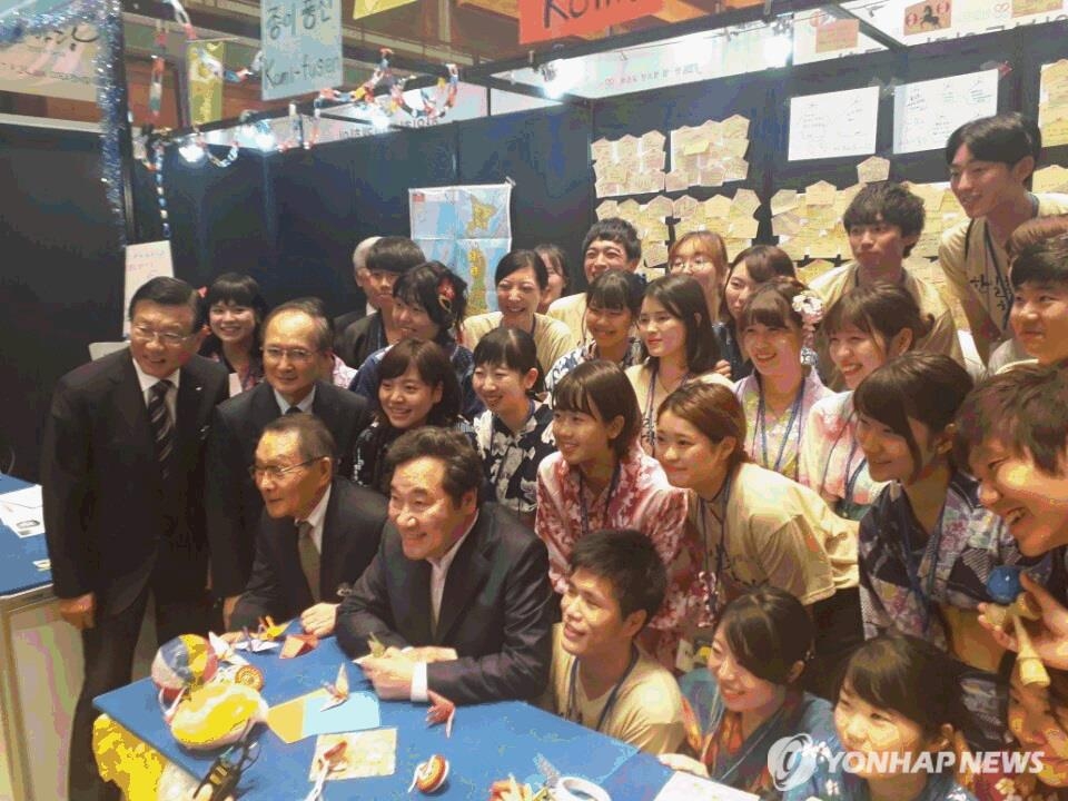会場で日本の大学生と記念撮影する李首相（最前列左から２人目）＝２４日、ソウル（聯合ニュース）