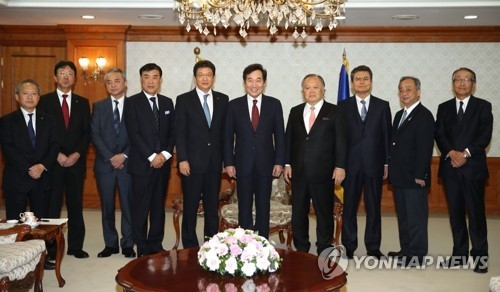 日本の旅行会社のトップらと記念撮影を行う李首相（左端から６人目）＝１０日、ソウル（聯合ニュース）