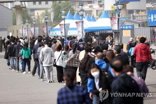 ソウル駅の広場に設置された新型コロナウイルスの臨時検査所の前で順番を待つ人々=7日、ソウル(聯合ニュース)