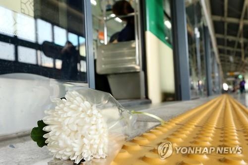 '스크린도어 앞에 놓여진 국화꽃'