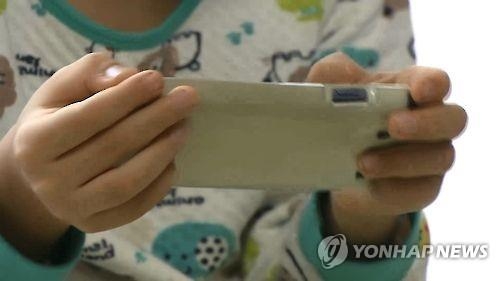 스마트폰으로 영상 시청하는 아동