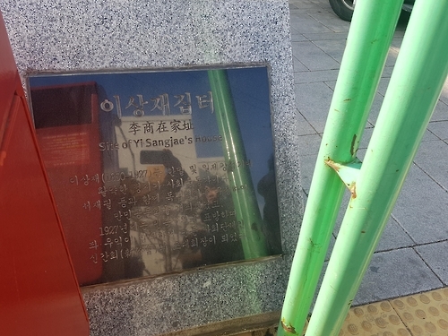 우체통과 버스정류장 사이에 놓인 이상재 집터 표지