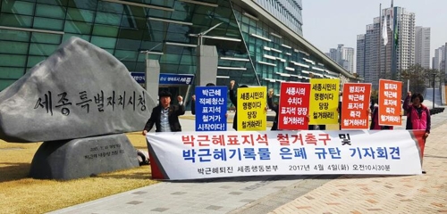 '박근혜 정권 퇴진 세종비상국민행동본부' 관계자가 4일 박근혜 전 대통령의 친필 휘호가 적힌 세종시청 앞 표지석 앞에서 "박근혜 친필 표지석을 즉각 철거하라"고 주장하고 있다. 2017.4.4