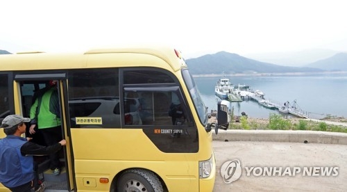 배에서 내려 풍산초교 투표소를 가는 버스에 오르는 주민들.