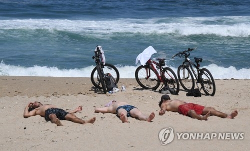 (강릉=연합뉴스) 유형재 기자 = 2일 강원 강릉시 경포해수욕장을 찾은 외국인 관광객들이 백사장에서 일광욕을 즐기고 있다. 2017.6.2 yoo21@yna.co.kr