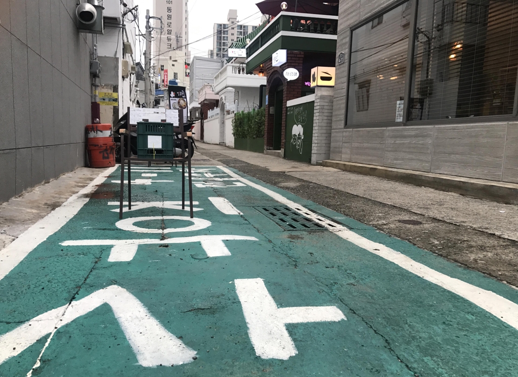 온천천 카페거리에 불법 주정차를 못하도록 한 주민이 의자를 놔두고 있다.