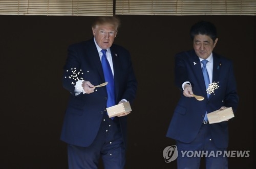 처음에는 스푼으로 잉어밥을 준 도널드 트럼프 미국 대통령과 아베 신조 일본 총리