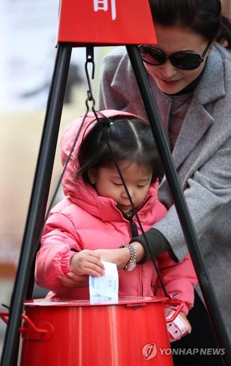 서울 명동에서 모녀가 구세군 자선냄비에 기부하고 있다.