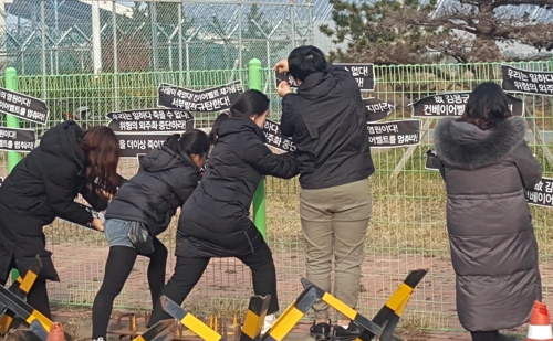 태안발전소 외벽에 요구사항을 붙이는 청년들