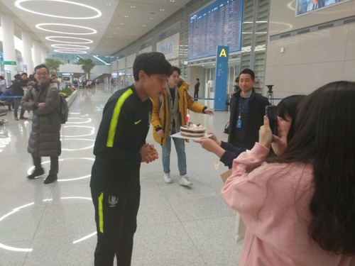 12일 인천공항 입국장에서 팬들이 선물한 생일 케이크의 촛불을 끄는 조영욱.