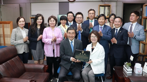 로라 전 회장이 이종걸 의원(앞줄 왼쪽)에 감사패를 전달하고 있다