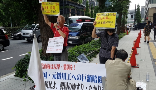 (도쿄=연합뉴스) 박세진 특파원 = 미쓰비시중공업 정기 주총이 열린 27일 오전 이 회사 본사가 있는 도쿄 마루노우치 니주바시 빌딩 앞에서 일본 우익단체 인사들이 '한국은 국제조약을 준수하라'는 주장이 적힌 손팻말을 들고 시위하고 있다. 