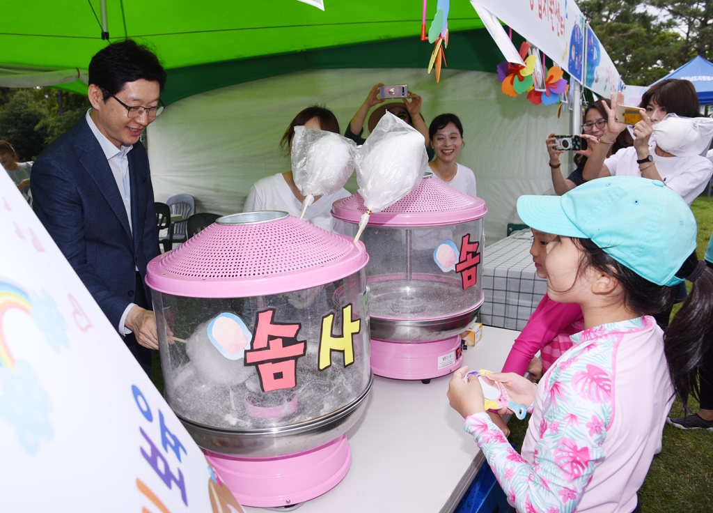 경남도청 물놀이장서 솜사탕 만드는 김경수 지사(왼쪽)