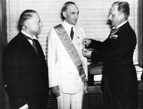 1938년, 미국 디트로이트에서 독일 영사가 히틀러의 훈장을 나치 정권의 전쟁 수행 준비에 큰 편의를 제공한 헨리 포드(가운데)에게 대신 수여하고 있다. (사진 = 오월의봄 제공)