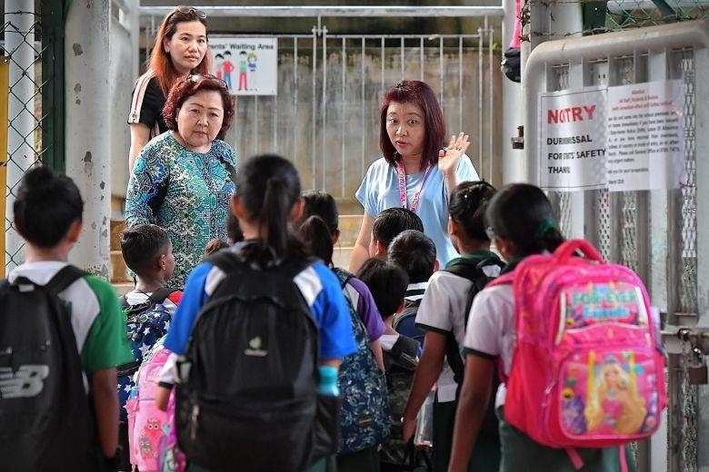 싱가포르 한 초등학교 교문 앞에서 교직원들이 학생들에게 의심 증상이 있는지, 최근 해외여행 이력이 있는지 등을 묻는 모습. [스트레이츠 타임스 캡처. 재판매 및 DB 금지]